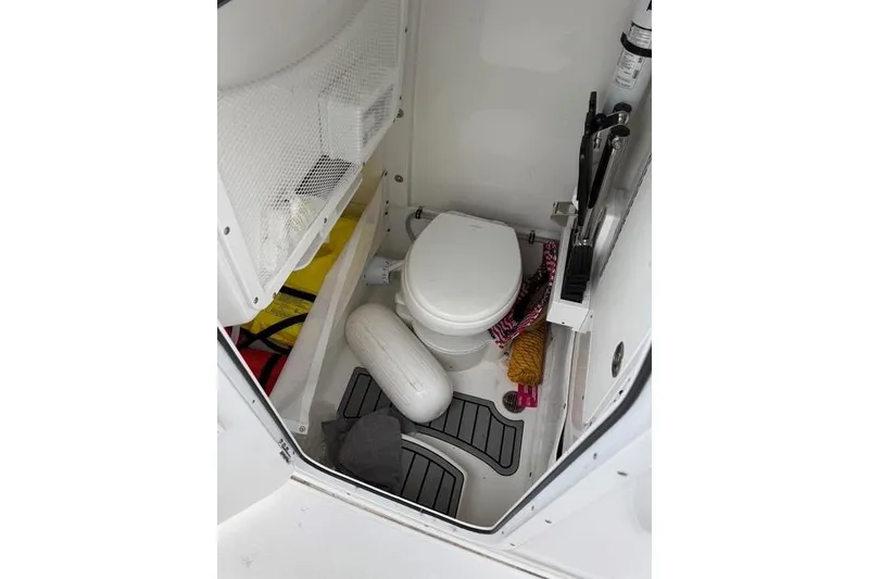 Slide: The Image of Interior of 2025 Sea Hunt Ultra 265 SE boat with toilet and storage items. - 15