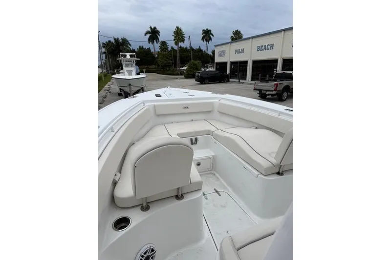 Slide: The Image of 2025 Sea Hunt Ultra 265 SE boat interior with white seating, parked near Palm Beach dealership. - 16