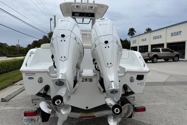 Slide: The Image of 2025 Sea Hunt Ultra 265 SE boat with dual outboard engines, parked at a dealership. - 4