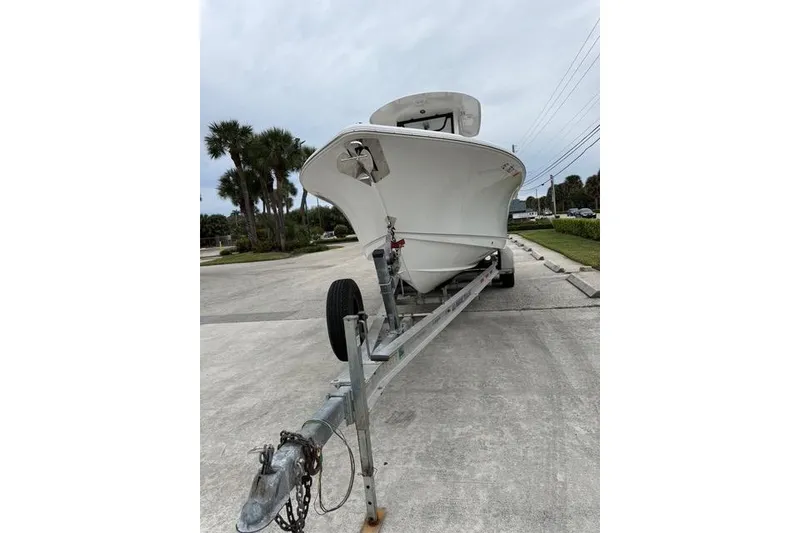 Slide: The Image of 2025 Sea Hunt Ultra 265 SE boat on trailer, parked on a concrete surface. - 5