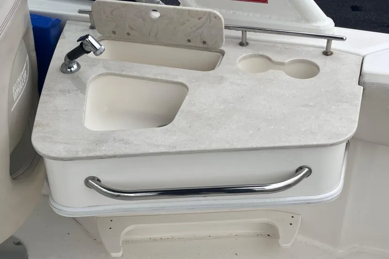 Slide: The Image of Boston Whaler 230 Vantage 2015 boat sink and countertop with faucet and cup holders. - 16