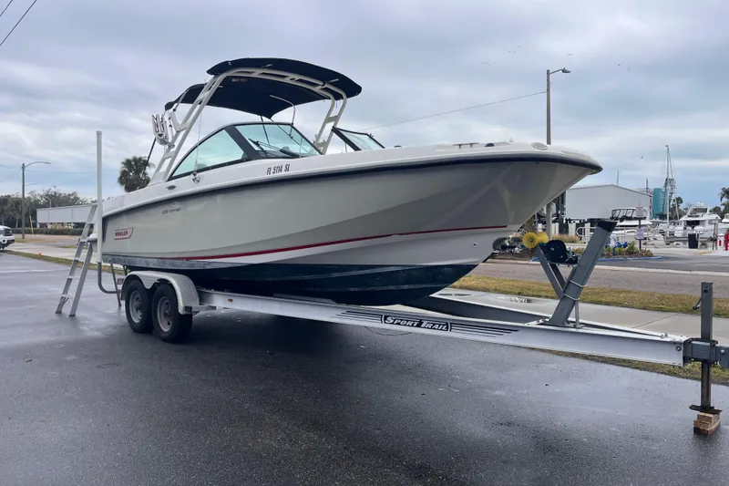 Slide: The Image of 2015 Boston Whaler 230 Vantage boat on trailer, parked outdoors. - 2