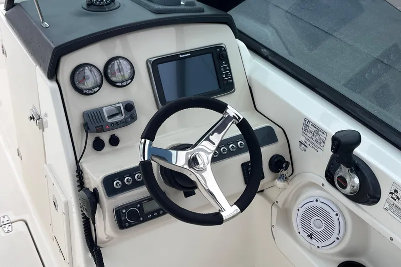 Slide: The Image of Dashboard of a 2015 Boston Whaler 230 Vantage boat with steering wheel and controls. - 22