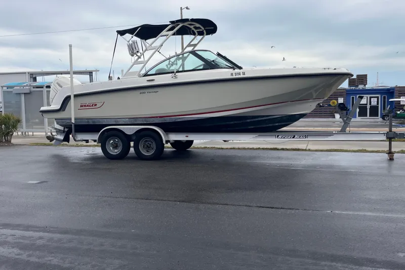 Slide: The Image of 2015 Boston Whaler 230 Vantage boat on trailer, parked outdoors. - 3
