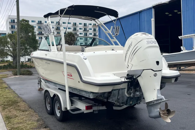 Slide: The Image of 2015 Boston Whaler 230 Vantage boat on trailer with Mercury engine, parked outdoors. - 43