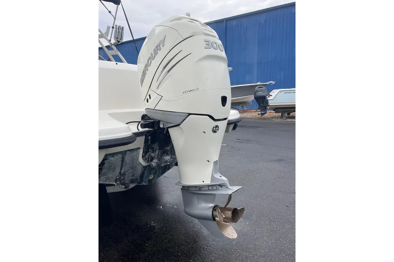 Slide: The Image of 2015 Boston Whaler 230 Vantage with Mercury 300 outboard motor, parked on wet pavement. - 7