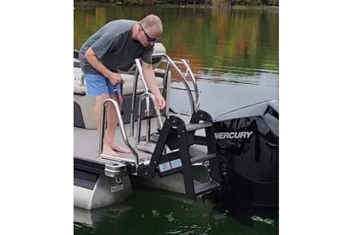 Slide: The Image of Man on Lowe LS 190 boat adjusting ladder near Mercury engine, 2026 model. - 4