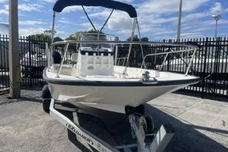 Slide: The Image of 2022 Boston Whaler 170 Montauk boat on trailer, parked outdoors under blue sky. - 3