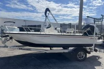 Slide: The Image of 2022 Boston Whaler 170 Montauk boat on trailer, parked outdoors under a blue sky. - 5