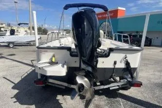 Slide: The Image of 2022 Boston Whaler 170 Montauk boat with outboard motor, parked outdoors. - 6