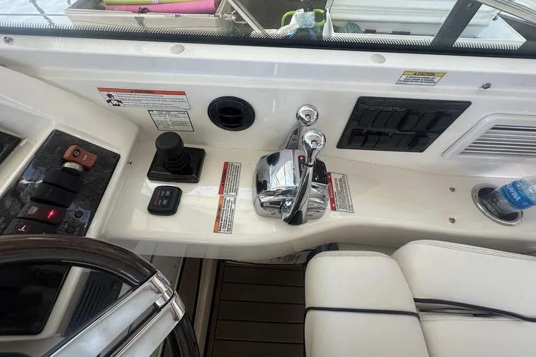 Slide: The Image of Control panel of a 2010 Sea Ray 450 Sundancer yacht with steering and throttle controls. - 19