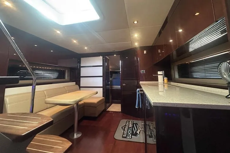 Slide: The Image of Luxurious interior of 2010 Sea Ray 450 Sundancer yacht with modern kitchen and seating area. - 23