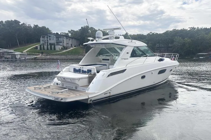 Slide: The Image of 2010 Sea Ray 450 Sundancer yacht on a serene lake with modern homes in the background. - 3
