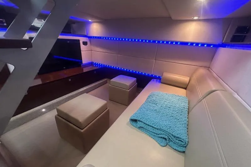 Slide: The Image of Luxurious interior of 2010 Sea Ray 450 Sundancer with blue LED lighting and cozy seating. - 32
