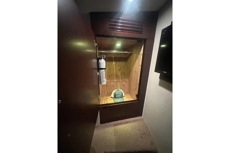 Slide: The Image of 2010 Sea Ray 450 Sundancer cabin closet with fire extinguisher and green cap. - 34