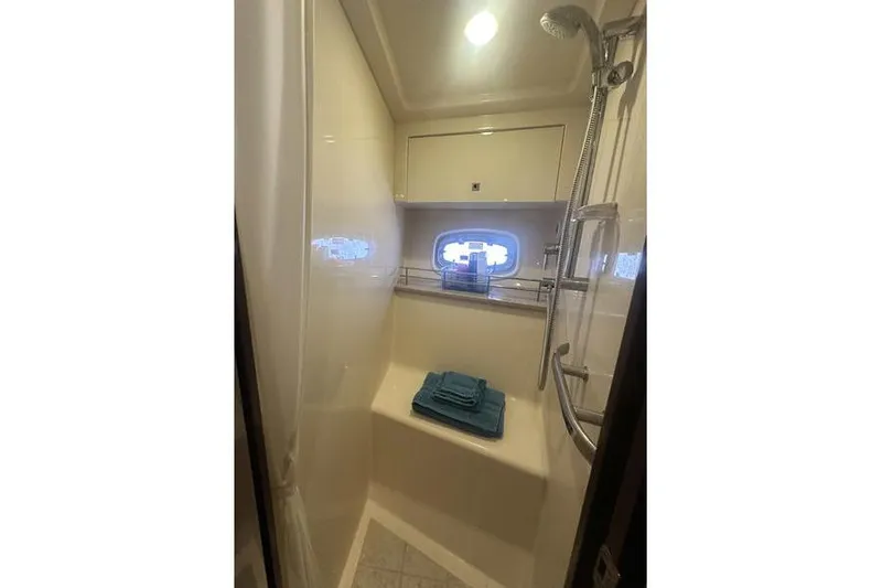 Slide: The Image of 2010 Sea Ray 450 Sundancer bathroom with shower, window, and folded towels. - 37