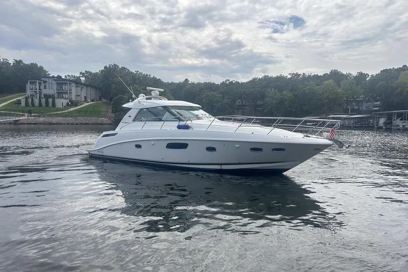 Slide: The Image of 2010 Sea Ray 450 Sundancer yacht on a calm lake with scenic background. - 5