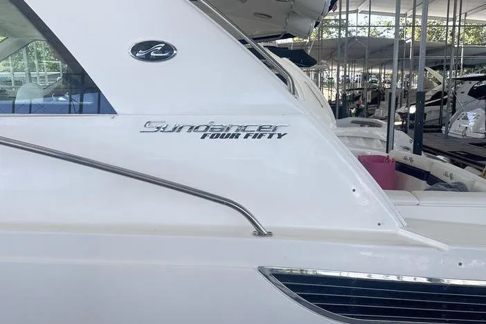 Slide: The Image of 2010 Sea Ray 450 Sundancer yacht, sleek white exterior, docked in marina. - 7