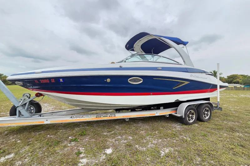 The Image of 2019 Crownline Eclipse E275 XS boat on trailer, blue and white design, parked on grass. - 0