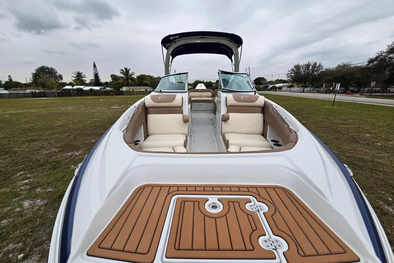 Slide: The Image of 2019 Crownline Eclipse E275 XS boat with spacious seating and elegant design on grassy area. - 11