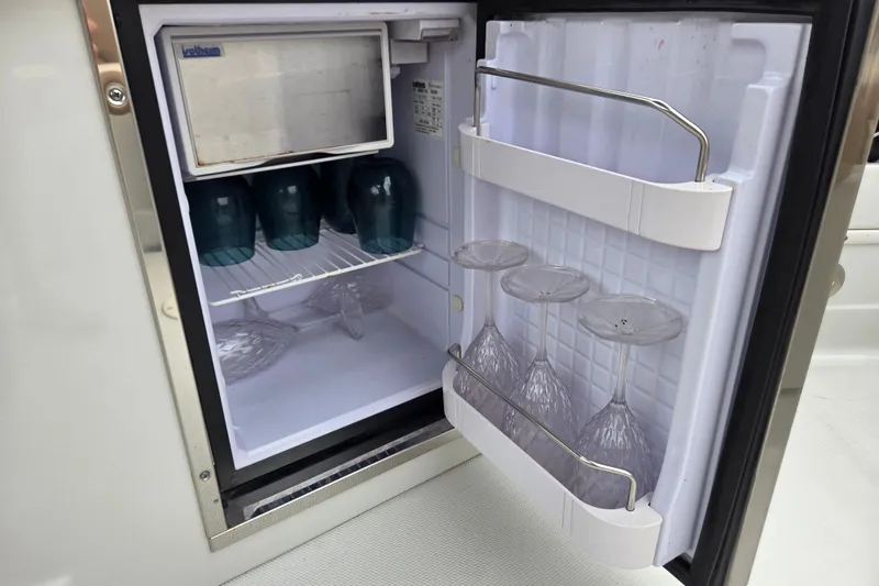 Slide: The Image of Mini fridge on 2019 Crownline Eclipse E275 XS with glasses stored inside. - 8