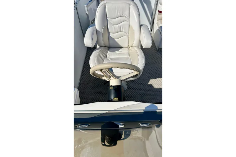 Slide: The Image of Captain's chair and steering wheel of 2007 Crest LE 2270 boat, featuring white upholstery. - 16