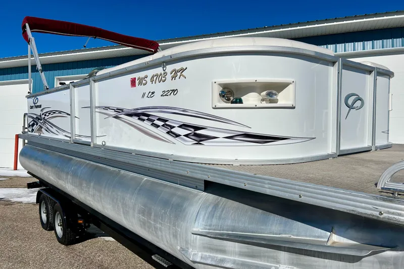 Slide: The Image of 2007 Crest LE 2270 pontoon boat with custom graphics, parked on a trailer. - 2