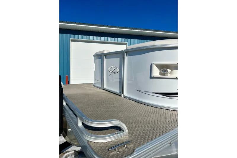 Slide: The Image of 2007 Crest LE 2270 pontoon boat near blue building under clear sky. - 28