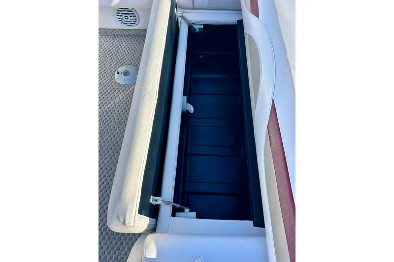 Slide: The Image of Open storage compartment on a 2007 Crest LE 2270 boat with cushioned seating. - 38