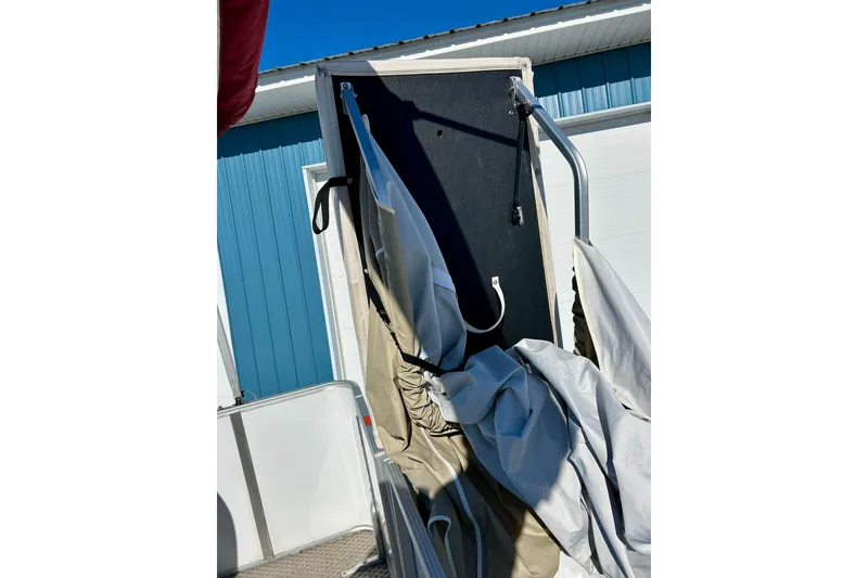 Slide: The Image of 2007 Crest LE 2270 boat with partially collapsed canopy against blue building. - 46