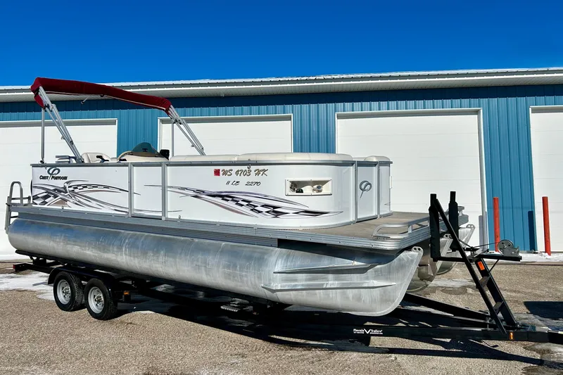 Slide: The Image of 2007 Crest LE 2270 pontoon boat on trailer, parked outside blue building. - 53