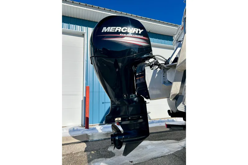 Slide: The Image of Mercury outboard motor on 2007 Crest LE 2270 boat, parked near blue building. - 8