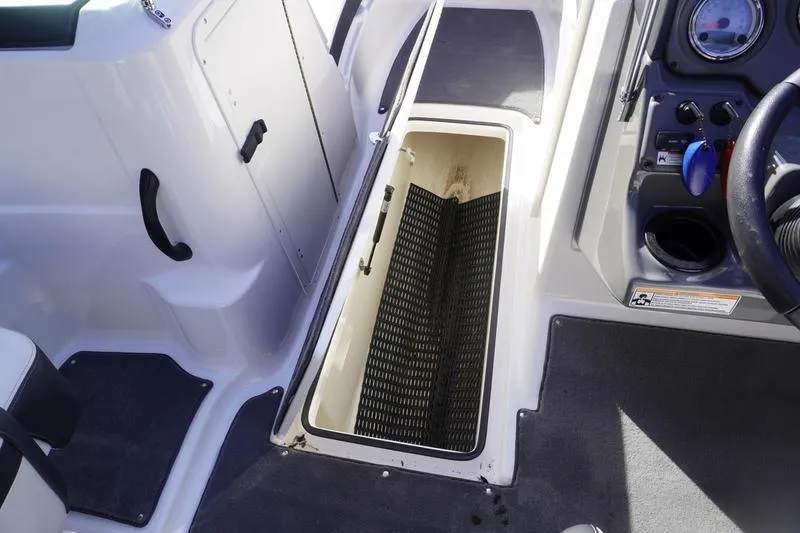 Slide: The Image of 2015 Yamaha SX210 boat interior with open storage compartment and control panel. - 14