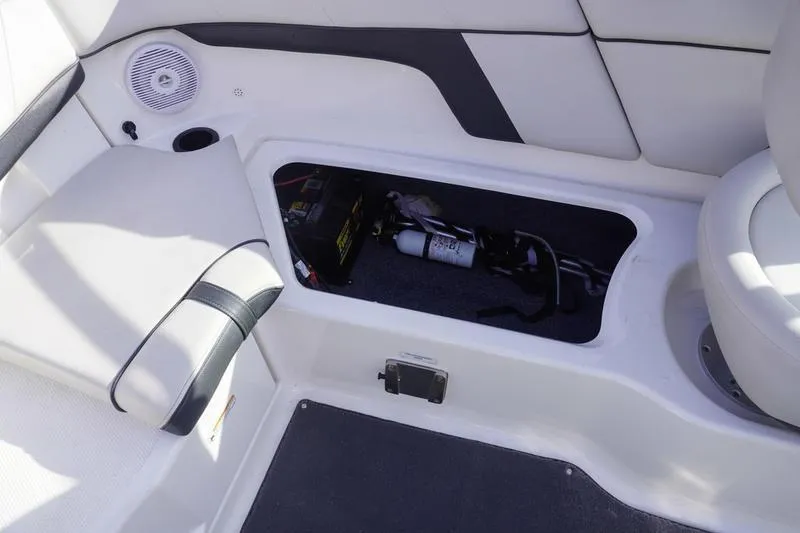 Slide: The Image of 2015 Yamaha Boats SX210 interior storage compartment with safety equipment and battery. - 24
