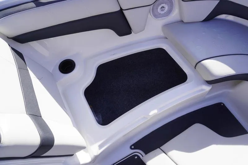 Slide: The Image of 2015 Yamaha Boats SX210 interior storage compartment with cushioned seating and speaker. - 8