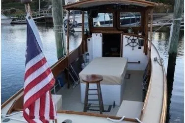 Slide: The Image of 1948 Burt Bros 26 boat docked, featuring American flag and classic wooden design. - 4