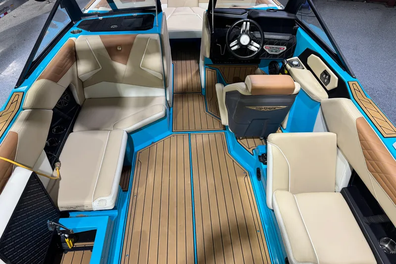 Slide: The Image of 2023 Nautique Super Air Nautique S23 interior with beige seating and blue accents. - 18