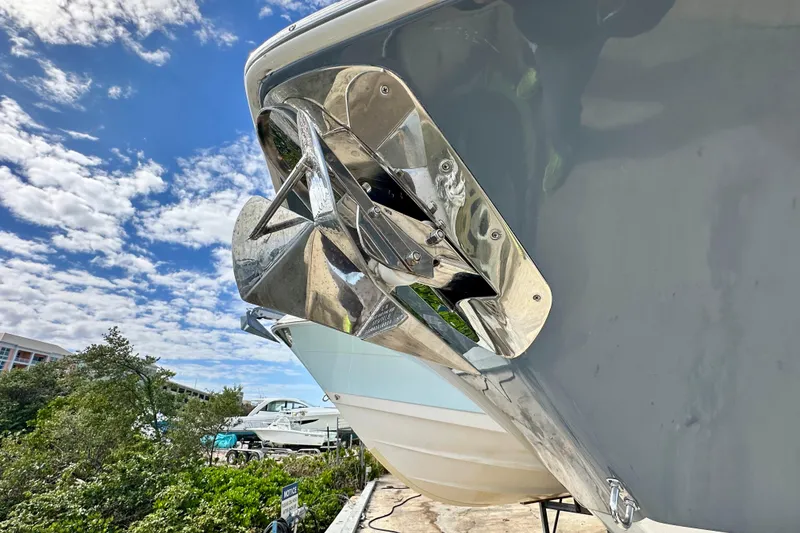 Slide: The Image of 2019 Tidewater 252 CC Adventure boat on calm blue water near waterfront homes. - 11