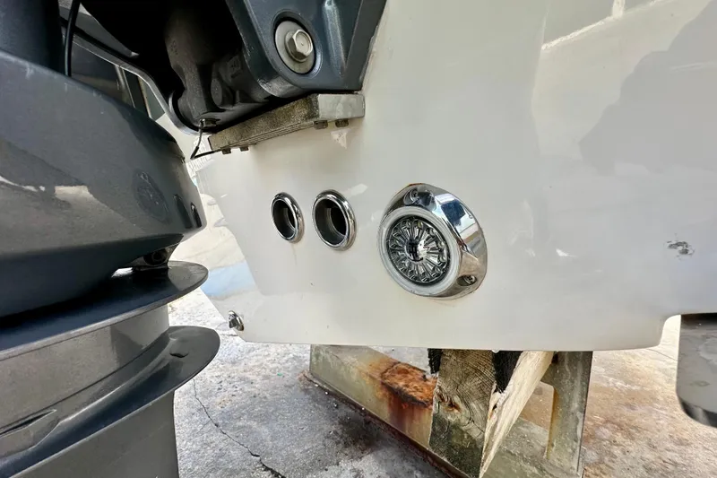 Slide: The Image of 2019 Tidewater 252 CC Adventure boat cruising on a sunny day near waterfront homes. - 12