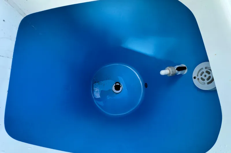 Slide: The Image of 2019 Tidewater 252 CC Adventure boat cruising on a sunny day near a marina. - 18