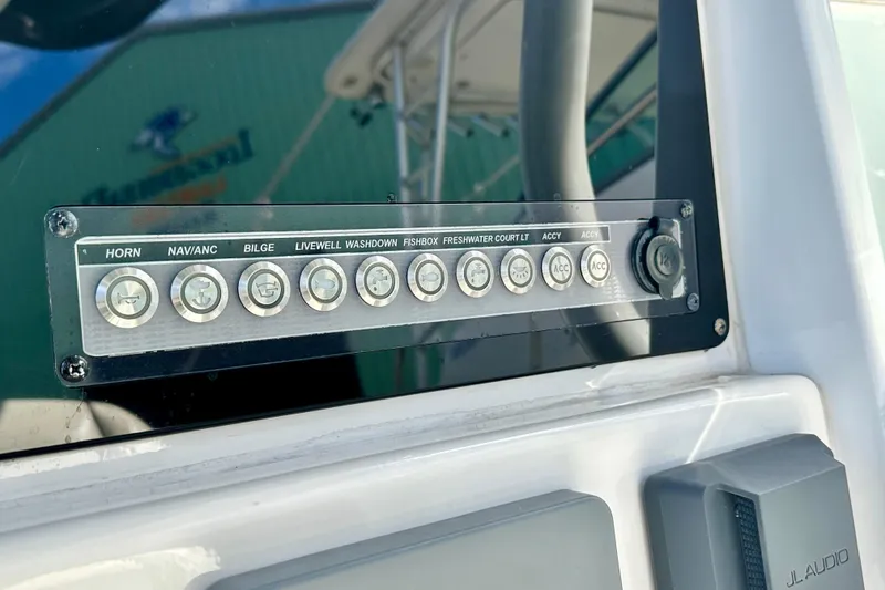 Slide: The Image of 2019 Tidewater 252 CC Adventure boat with outboard motor, docked under a cloudy sky. - 26