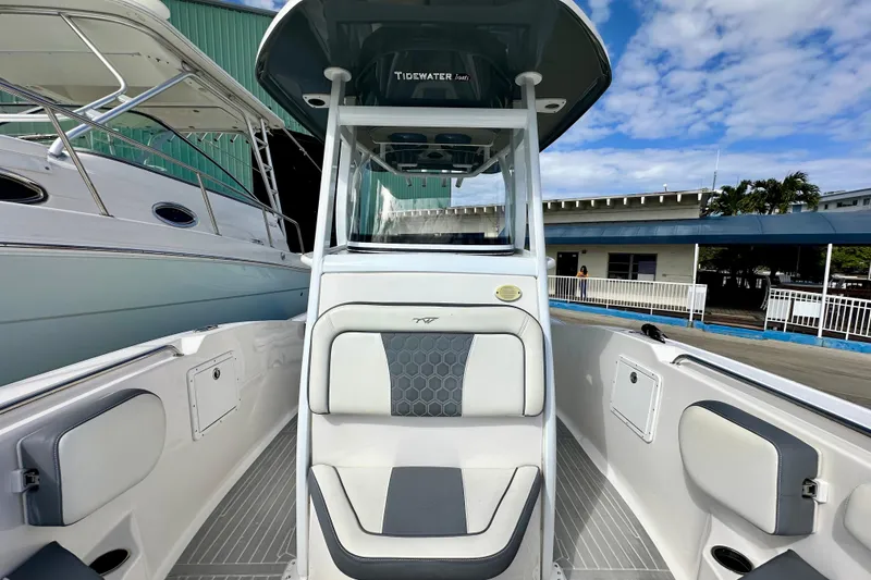 Slide: The Image of 2019 Tidewater 252 CC Adventure boat with dual engines and spacious seating, docked outdoors. - 32