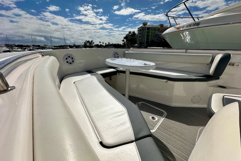 Slide: The Image of 2019 Tidewater 252 CC Adventure boat interior with seating and table under a sunny sky. - 53