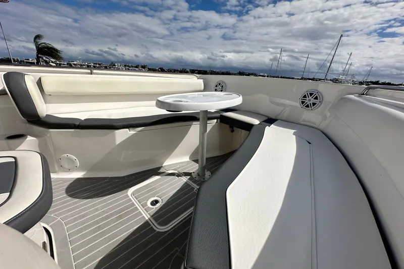 Slide: The Image of 2019 Tidewater 252 CC Adventure boat interior with seating and table under cloudy sky. - 54
