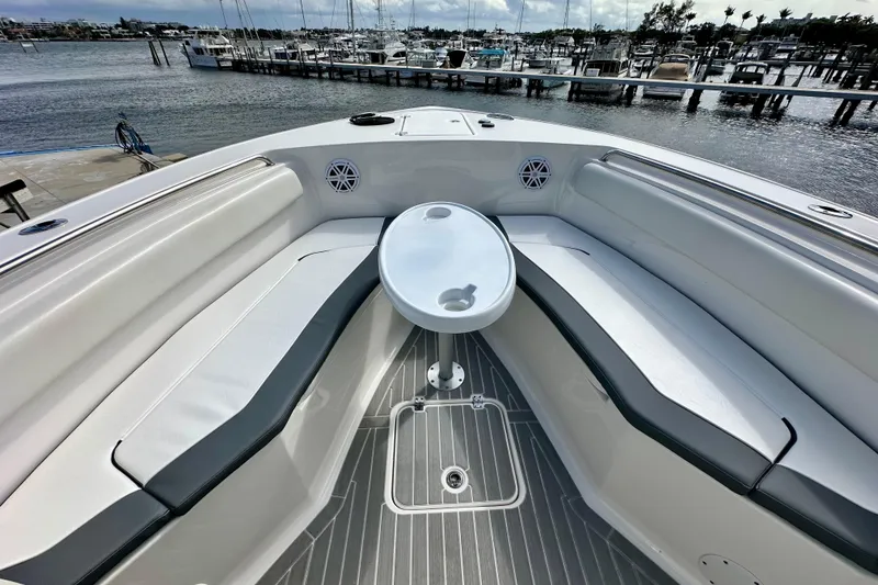 Slide: The Image of 2019 Tidewater 252 CC Adventure boat interior with seating and table, docked at marina. - 55