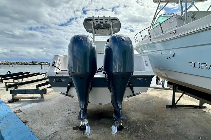 Slide: The Image of 2019 Tidewater 252 CC Adventure boat cruising on a sunny day near coastal homes. - 7