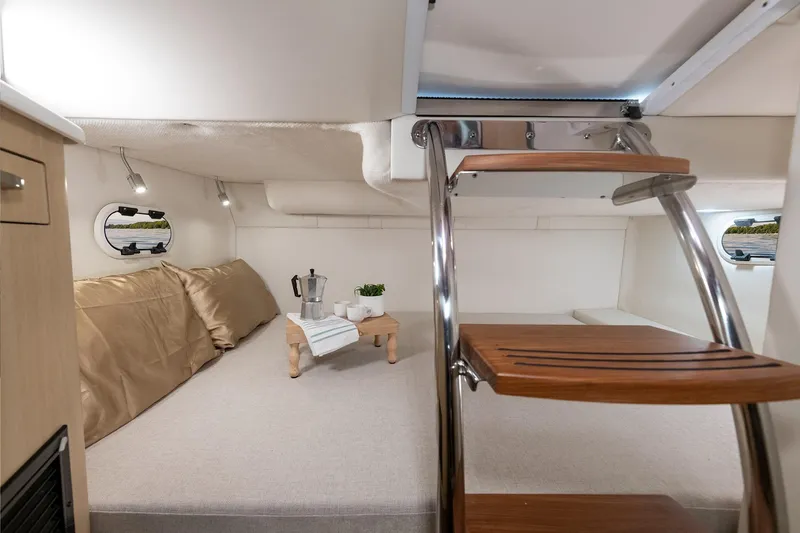 Slide: The Image of 2016 Regal 28 Express cabin interior with cozy seating and wooden steps. - 7