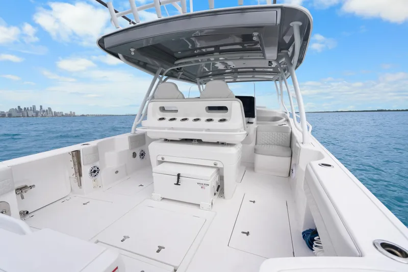 Slide: The Image of 2024 Intrepid 41 Valor boat interior with seating, ocean view, and city skyline. - 19