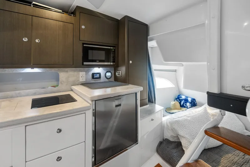 Slide: The Image of 2024 Intrepid 41 Valor cabin interior with kitchenette and cozy sleeping area. - 22