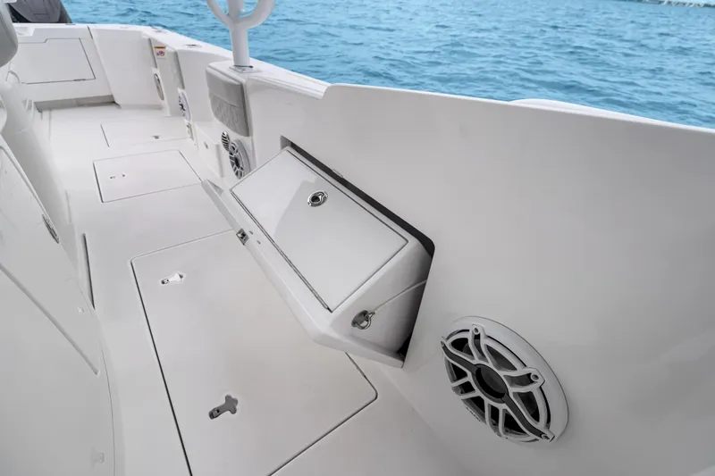 Slide: The Image of 2024 Intrepid 41 Valor boat interior with storage compartment and speaker, overlooking the ocean. - 27